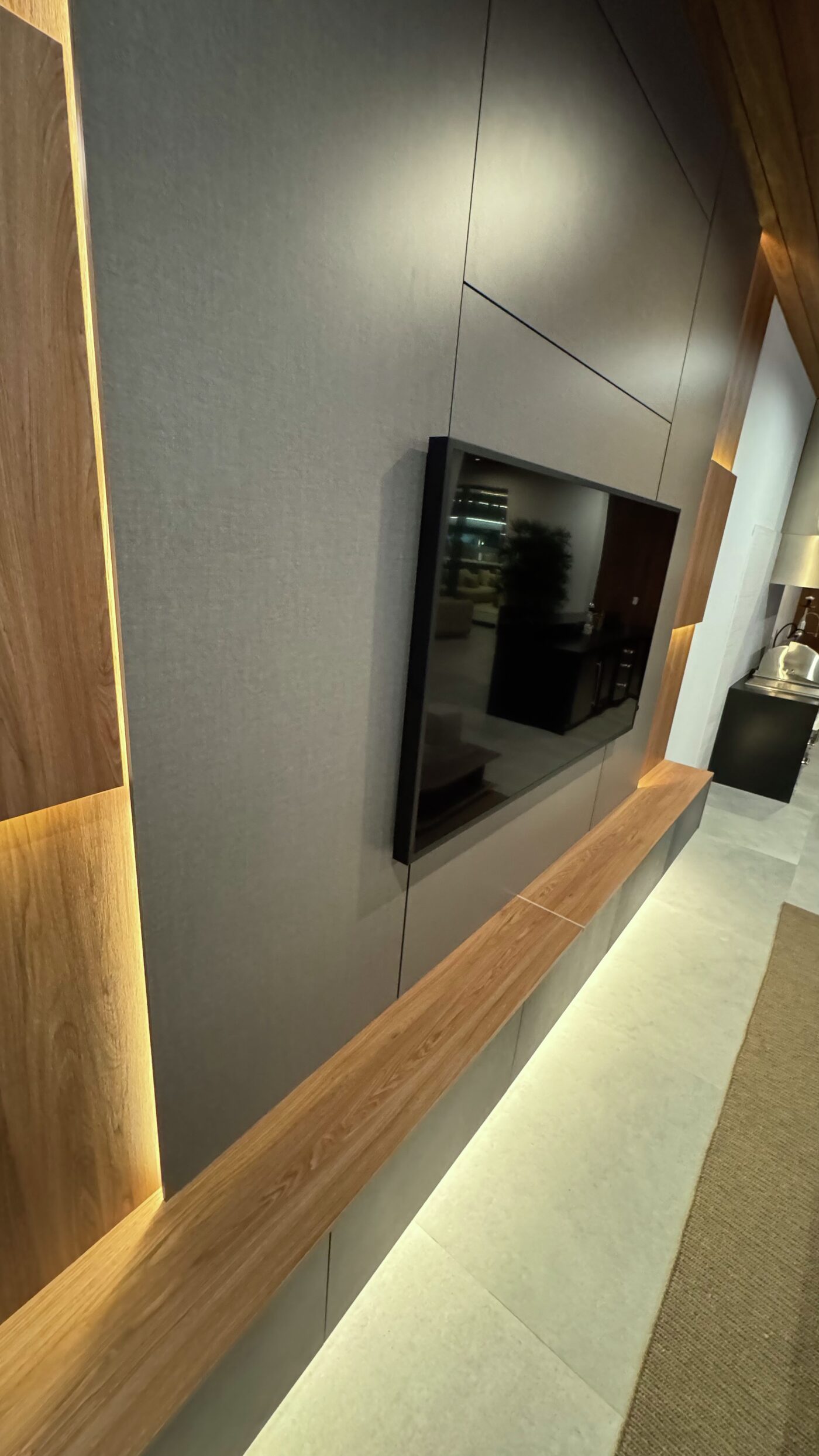 Side view of the TV wall with light along the base of the floating cabinet.